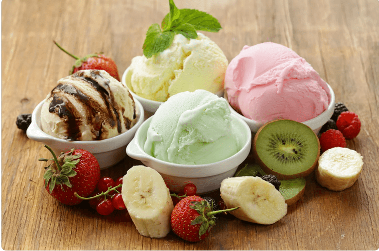 vier verschiedene eiskugeln mit obst garniert