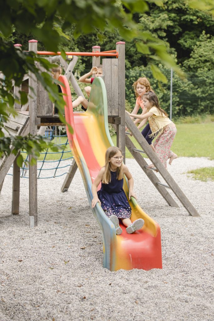 kinder rutschen von einer bunten rutsche